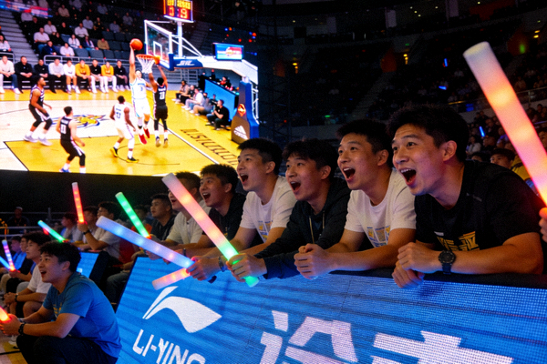 球迷正在通过大屏幕观看激烈的篮球比赛直播